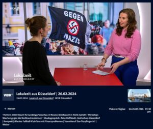 Screenshot aus der Lokalzeit Düsseldorf vom 26.02.2024 - die Moderation und FORENA-Studiogast im WDR-Studio, im Hintergund Bilder von der Demonstartion vom 27.01.2024.
